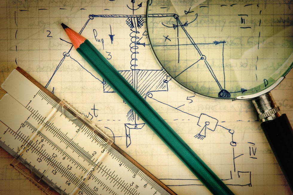 Engineering drawings with ruler pencil and magnifiying glass