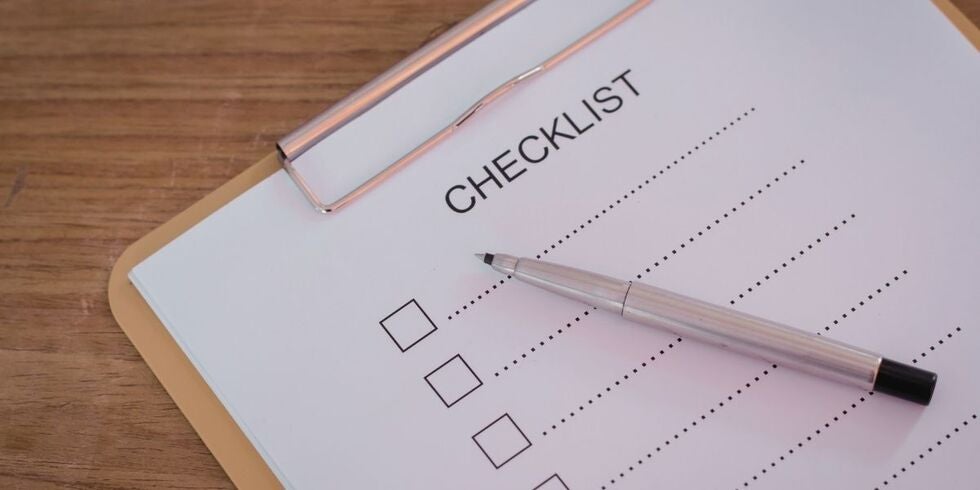 A checklist on a clipboard with a pen.