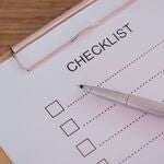 A checklist on a clipboard with a pen.