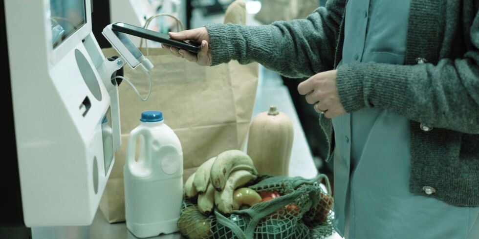 A woman using a self-checkout at a store.
