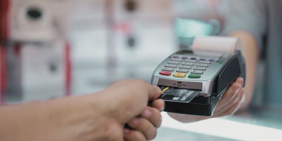 A person using a credit card at a terminal.