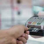 A person using a credit card at a terminal.