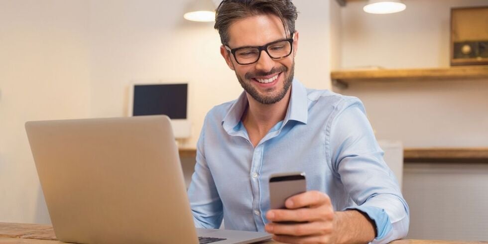 A photo of a man receiving good news on his phone. 