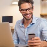 A photo of a man receiving good news on his phone. 