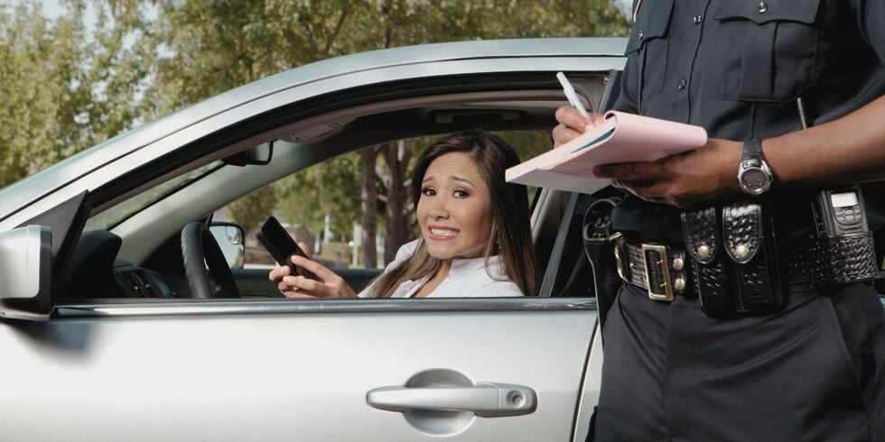 A woman receiving a ticket from a police officer.