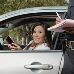 A woman receiving a ticket from a police officer.