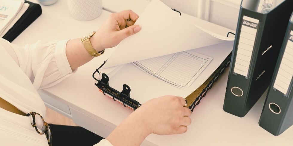A photo of a woman looking at paper on a clipboard