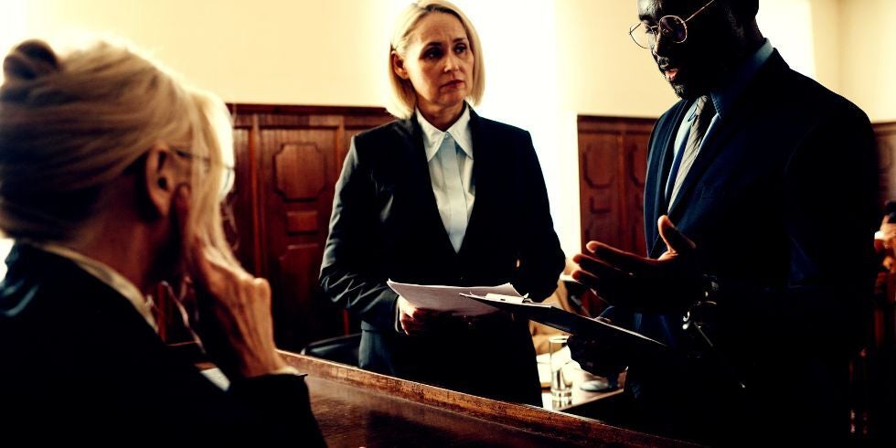 Two lawyers talking in front of a judge.