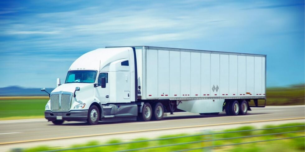 A semi-truck driving on the highway. 