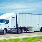 A semi-truck driving on the highway. 