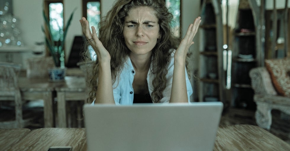 A woman using a computer, frustrated.