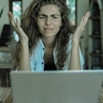 A woman using a computer, frustrated.
