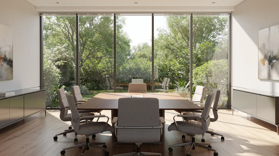 The image depicts a professional office space featuring a large conference table surrounded by comfortable chairs, with expansive windows that offer a view of lush green trees outside. This inviting environment is ideal for discussions about estate planning, including topics such as revocable living trusts and asset distribution among family members.