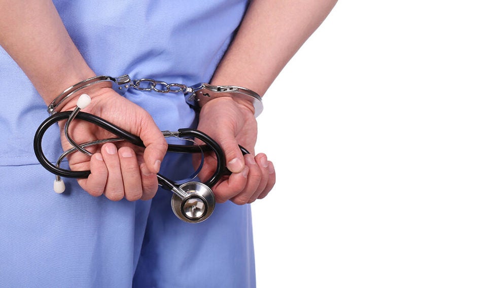 Nurse with dui in cuffs holding stethoscope