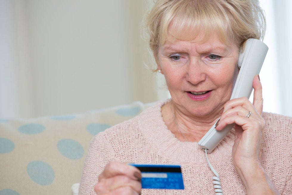 Lady giving her credit card number to a collections scammer calling on the phone.
