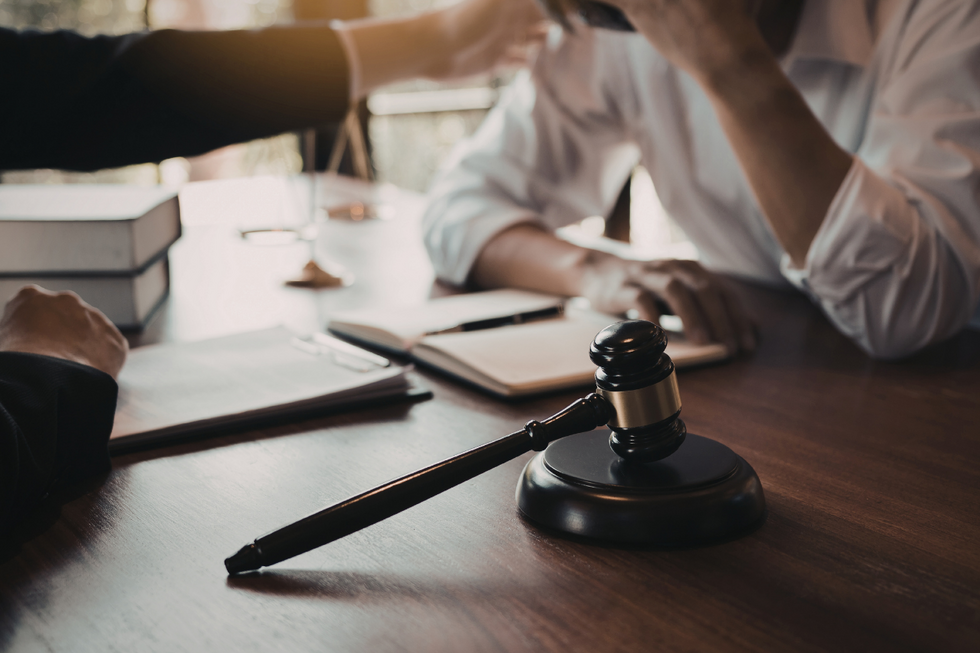 An immigrant, visibly worried, consulting with an immigration attorney—a common sight as immigration delays continue.