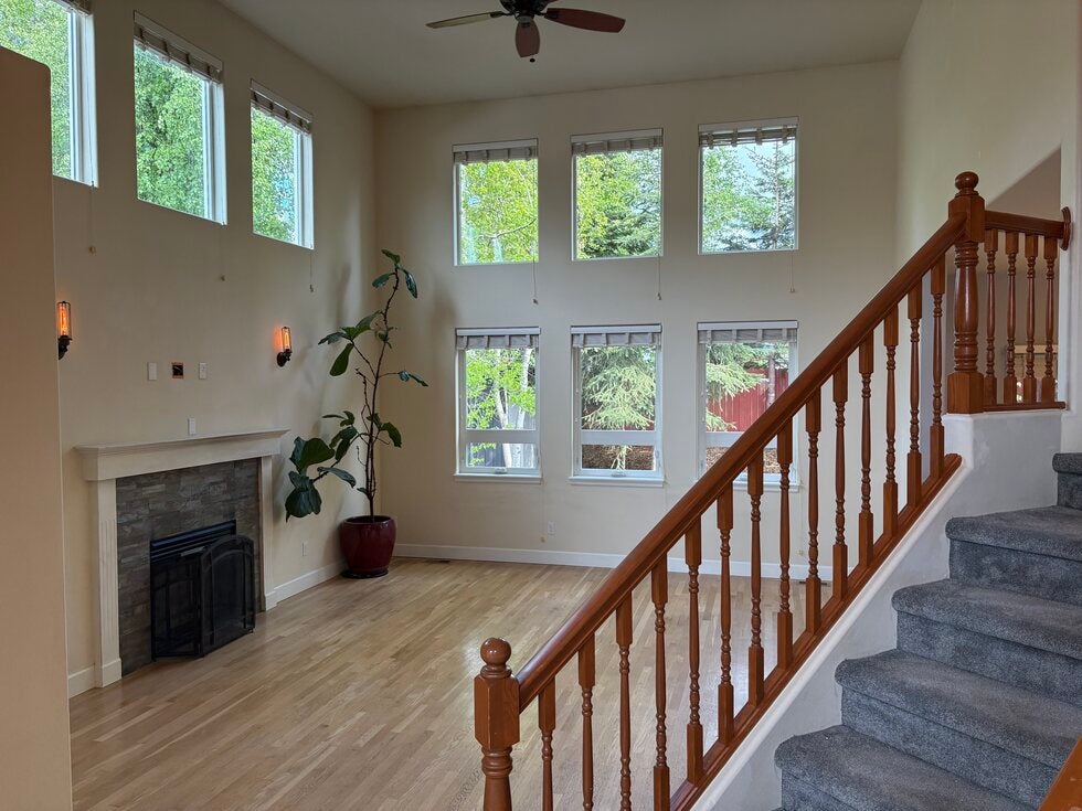 Photo of view of great room with fireplace, wall of windows, and vaulted ceilings from front entrance