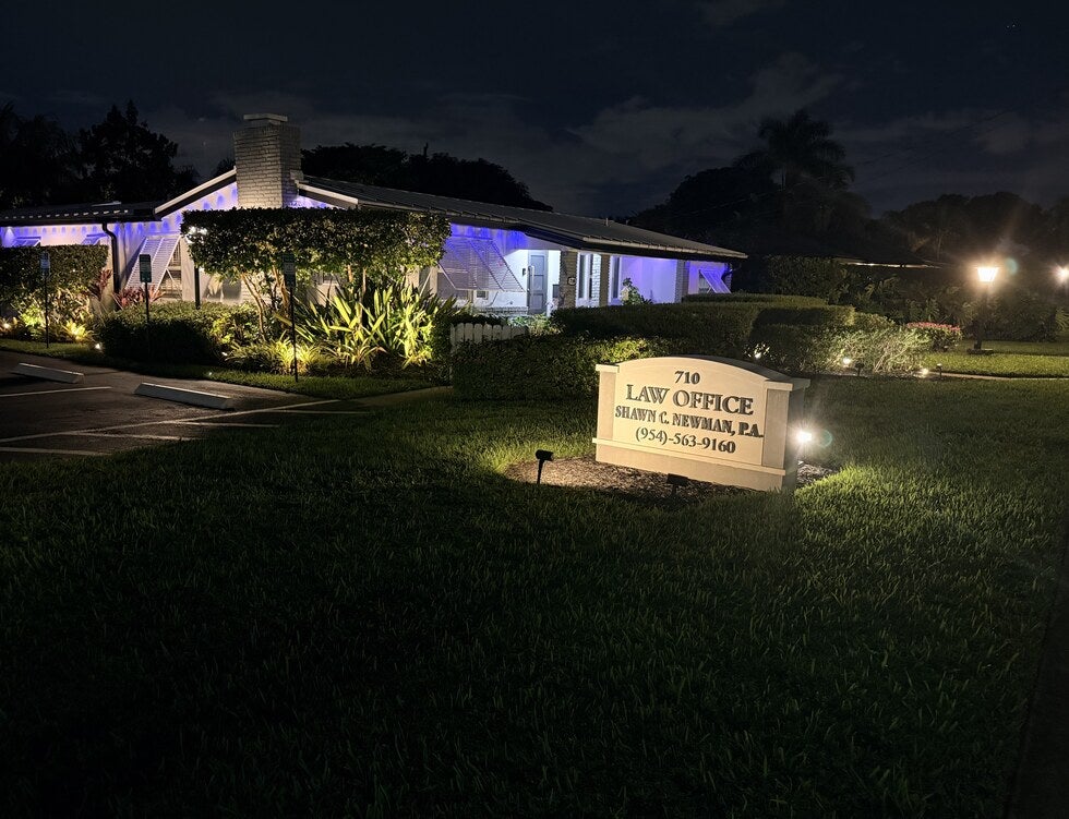 Night exterior of the Shawn C. Newman law office with monument sign and lit facade
