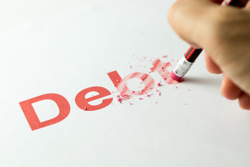 red pencil erasing the word debt on paper.