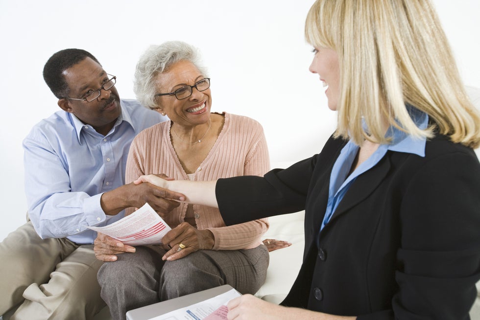 Senior African American couple consult with attorney.