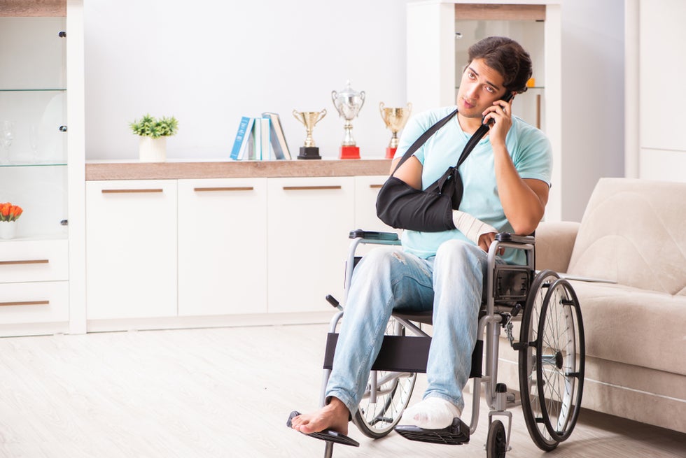 Man in wheelchair using his phone to call and consult a truck accident lawyer in California.
