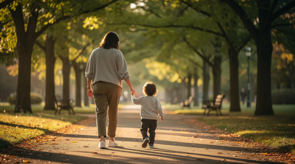 A parent and child are walking hand in hand along a serene, tree-lined path, symbolizing the nurturing bond in an adoptive family. This image reflects the importance of the parent-child relationship in the adoption process, highlighting the joy of creating a loving family through stepparent adoption or other forms of adoption in Texas.