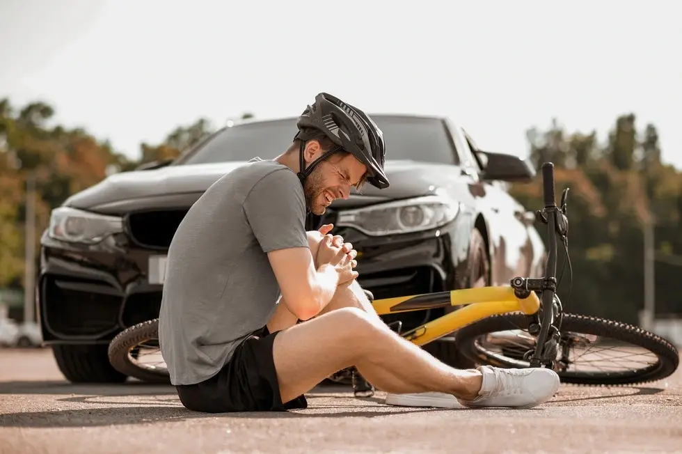 Distressed man holding his leg after a bicycle accident, illustrating the need for a personal injury lawyer from Villani & DeLuca P.C. in Monmouth Beach, NJ.