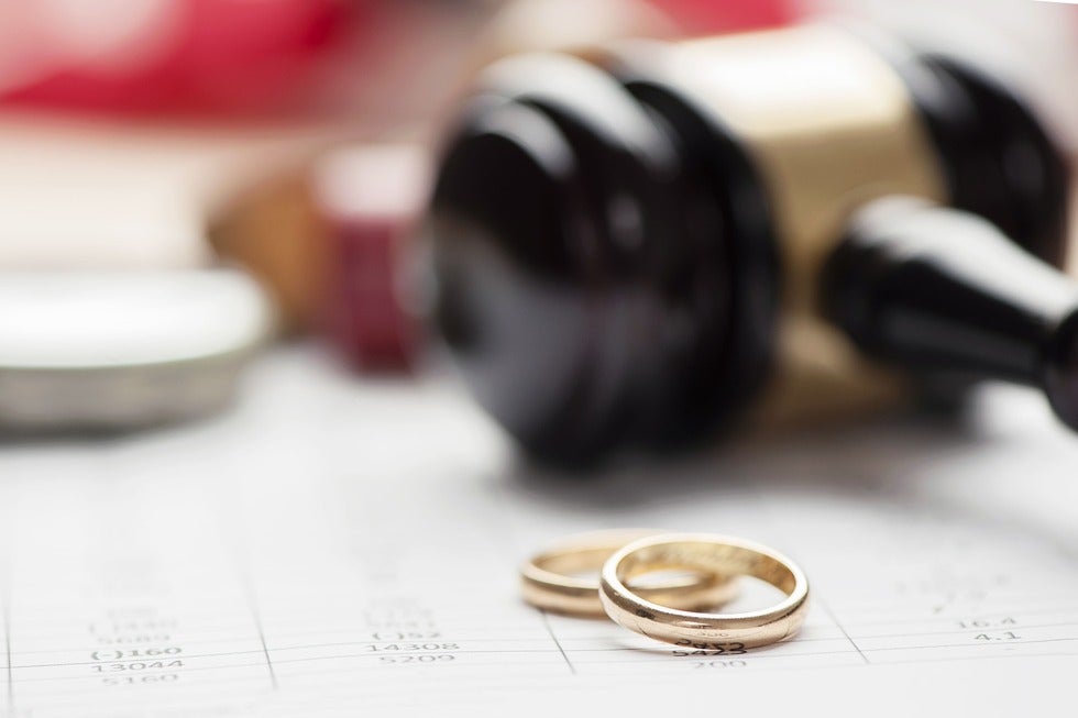 Wedding rings resting on a legal document, symbolizing divorce and family law services in Middletown, New Jersey.