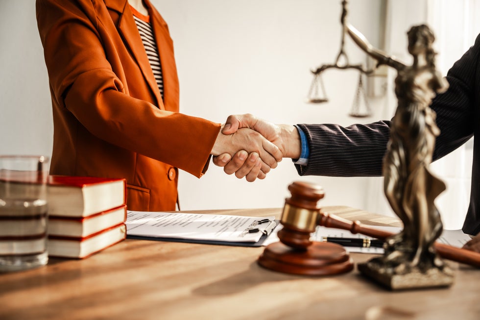 Lawyer and client shaking hands in office, representing full legal services available in Ship Bottom, NJ
