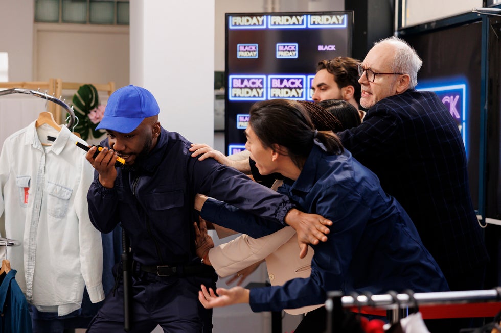 Security guard being overwhelmed by crowd during Black Friday chaos, symbolizing criminal law situations in Stafford, NJ