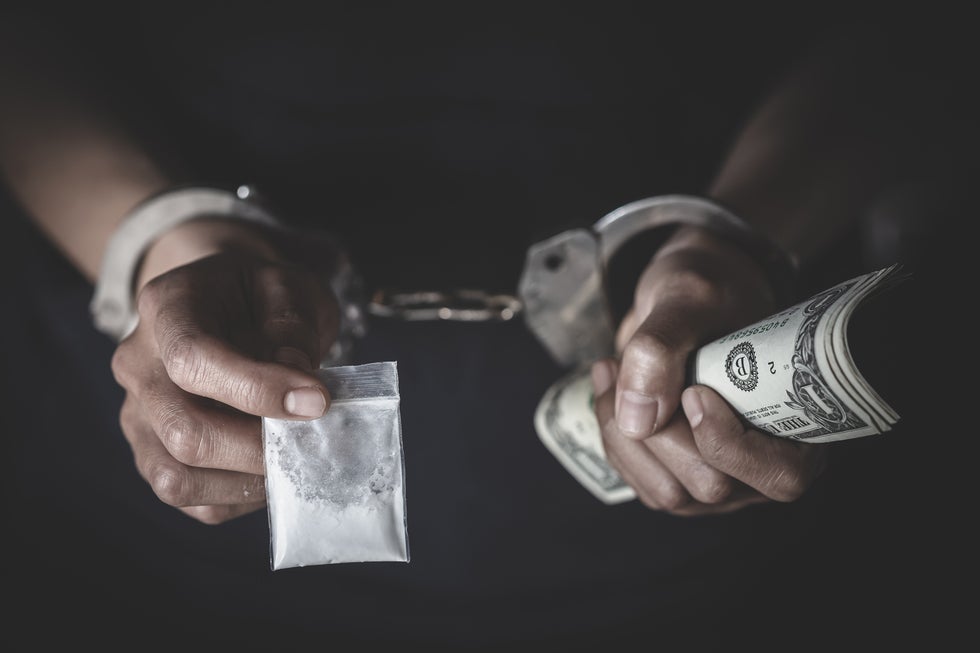 Man hand with money and sachet white substance