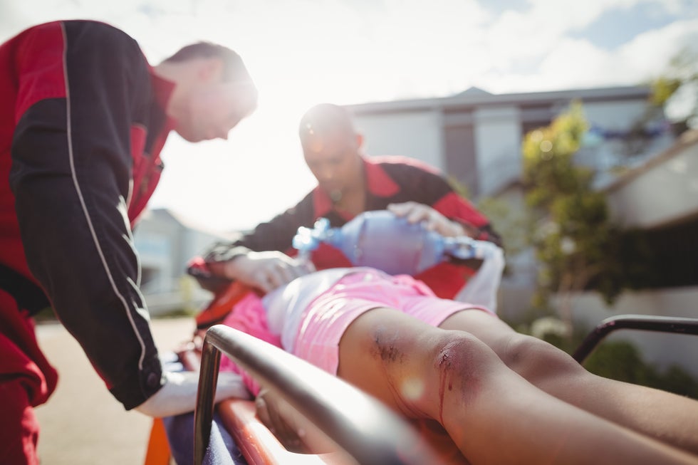 paramedic giving oxygen to injured girl. 