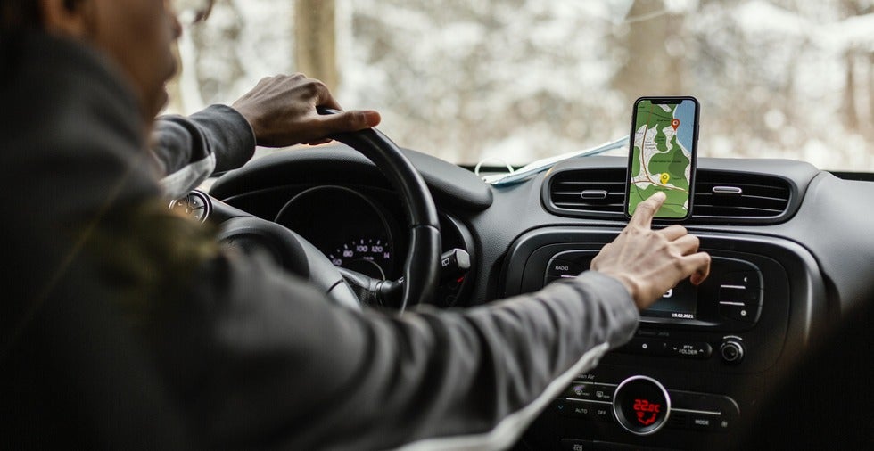 A man in a car using a GPS app to navigate, illustrating technology's role in rideshare accident claims in New Jersey.
