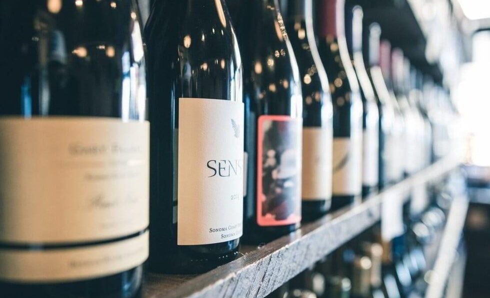 Row of wine bottles on a retail shelf, representing the process of buying a retail liquor license in New Jersey