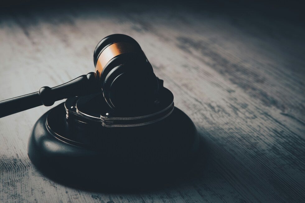 Judge's gavel resting on a sound block with handcuffs, symbolizing criminal defense legal representation in New Jersey
