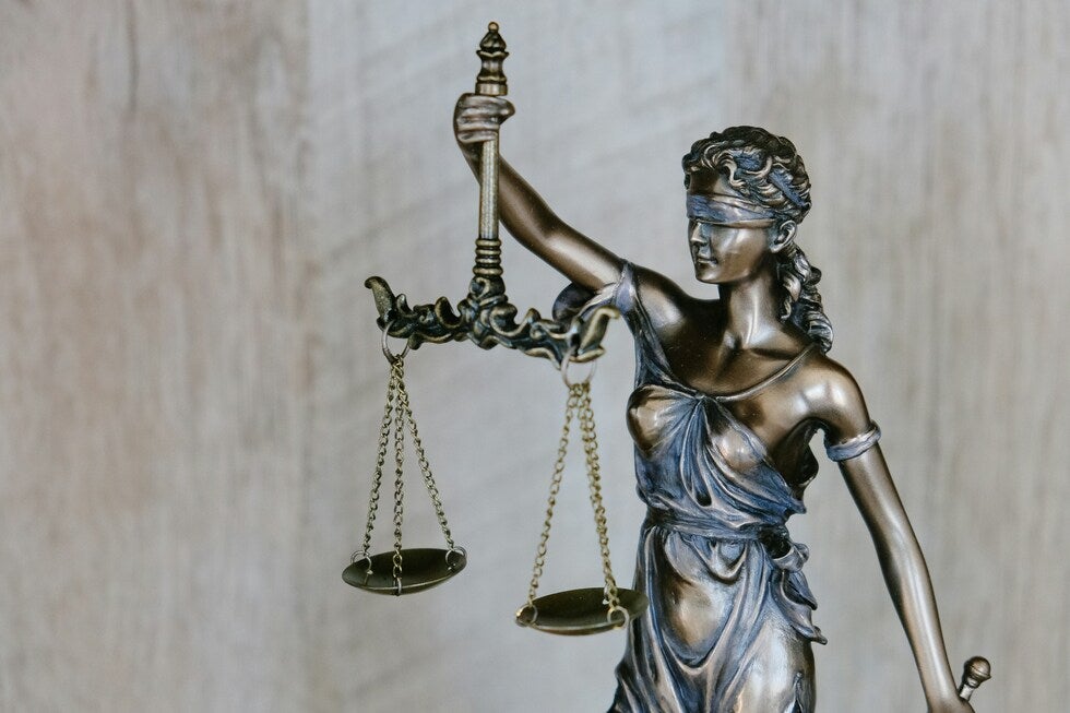 Bronze Lady Justice statue holding scales, symbolizing the legal process for assault charges in New Jersey