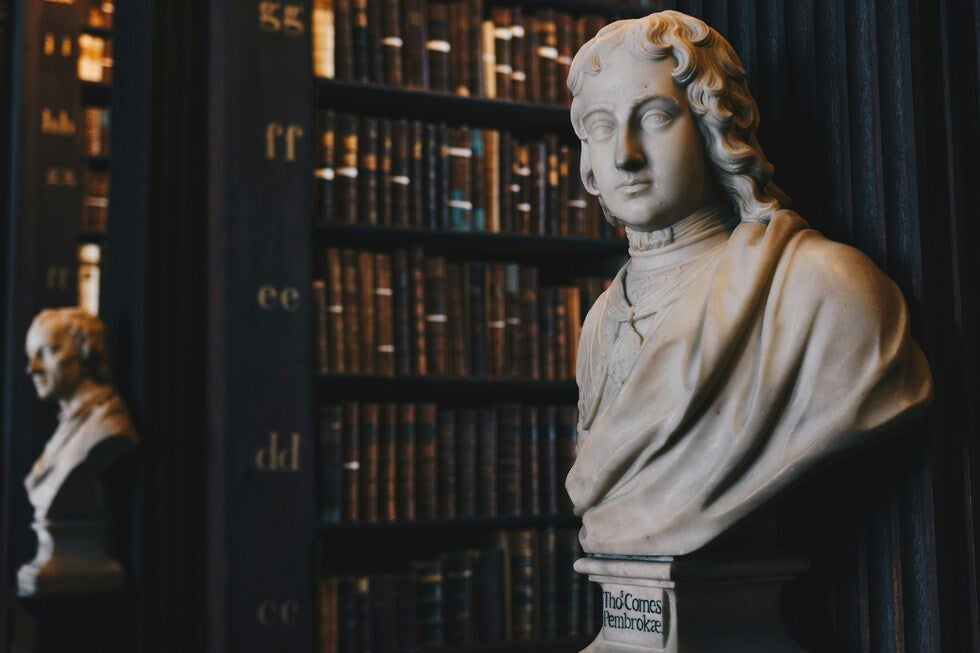 Marble bust in a dark law library representing legal authority in New Jersey assault cases involving police officers or public employees
