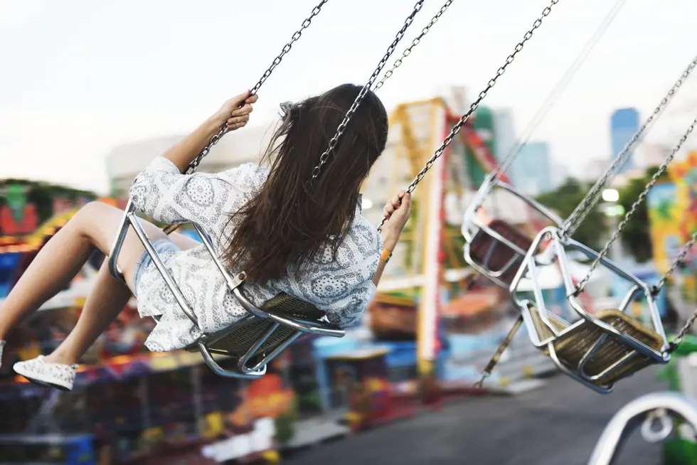 Woman riding a chain swing carousel ride at an amusement park