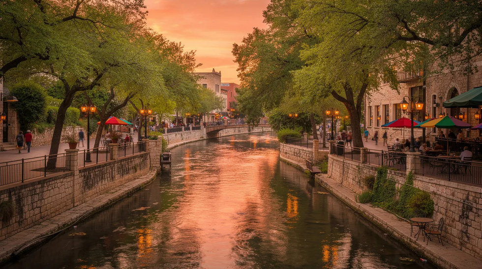 The image depicts the San Antonio River Walk at sunset, where vibrant hues of orange and pink fill the sky, casting a warm glow over the winding walkways and lush trees lining the river. This serene setting reflects the beauty of San Antonio, a city where experienced divorce attorneys are ready to assist families with legal matters such as divorce proceedings and child custody arrangements.