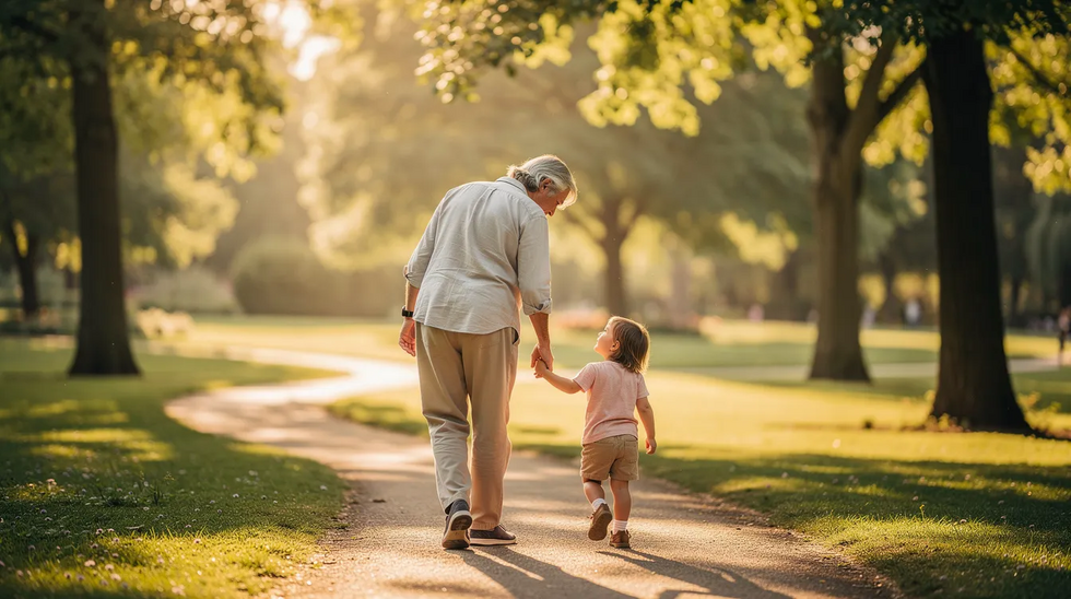 A grandparent and their young grandchild are joyfully walking hand in hand through a sunlit park, surrounded by lush trees, symbolizing the strong grandparent-grandchild relationship. This scene highlights the importance of family bonds and the emotional well-being of children, which can be vital in family law matters such as custody and visitation rights.