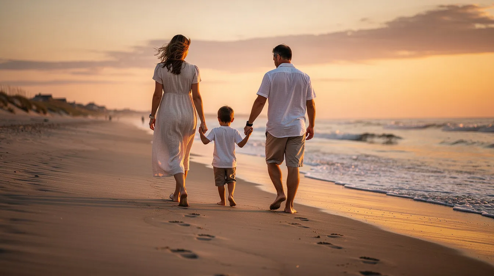 A family is walking together along a sandy Cape Cod beach at sunset, enjoying the warm hues of the sky and the gentle waves. This scene captures the essence of family bonds and the importance of planning for the future, such as through estate planning and revocable living trusts, to protect loved ones.
