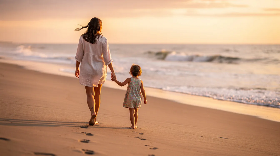 A parent gently holds a young child's hand while walking along a sandy beach, symbolizing the importance of family and nurturing relationships. This image reflects the careful consideration needed in estate planning, ensuring the family's future and protection of loved ones.