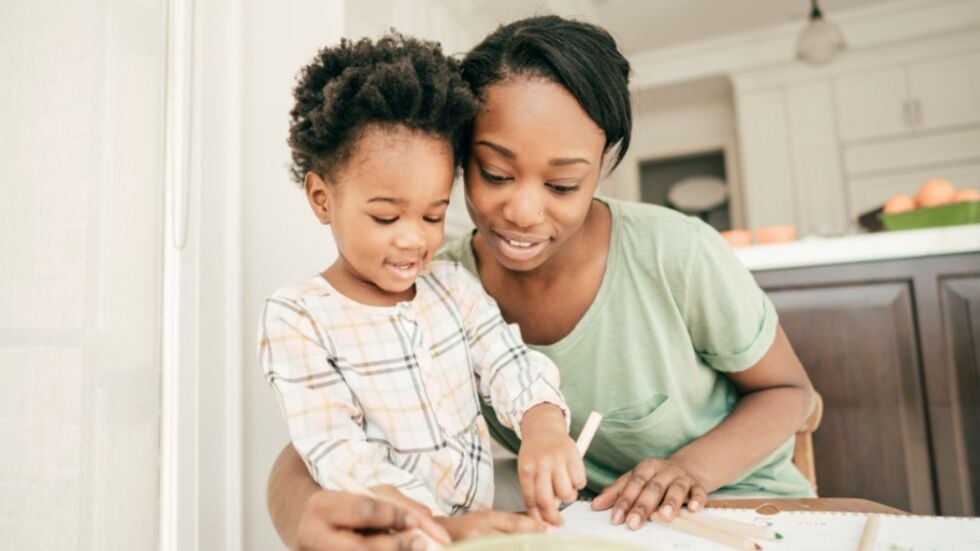 A woman and her daughter are coloring at the table, making the most of their time-sharing schedule.