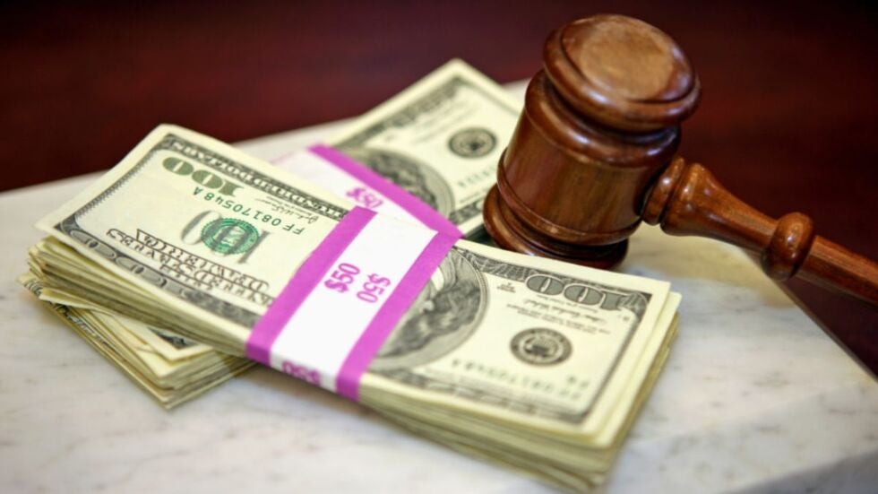 Stacks of money on a table with a gavel, representing attorney’s fees and costs of litigation.