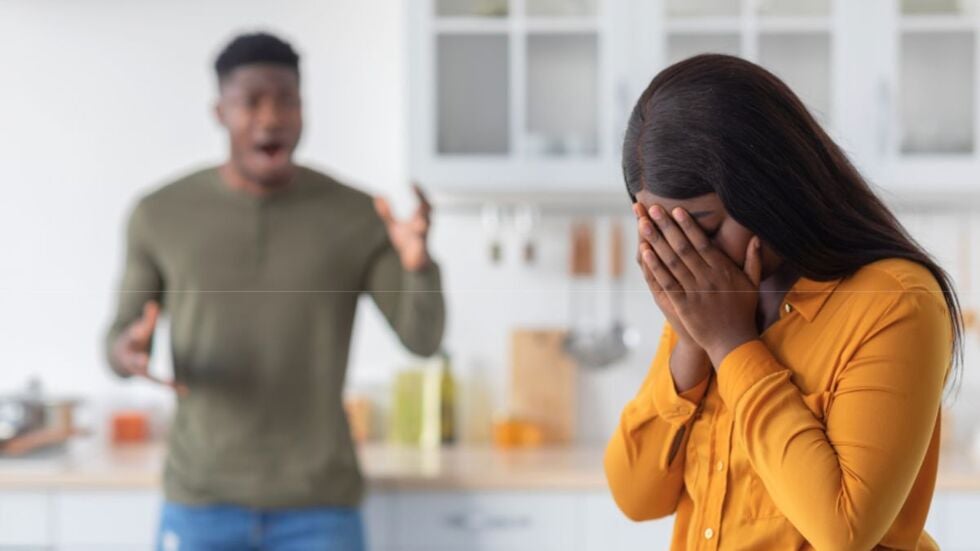 A woman is crying while a man is shouting in the background, demonstrating domestic violence.