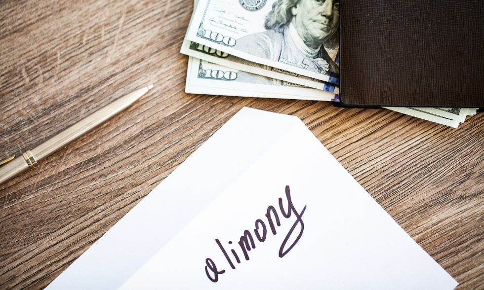 Some cash, a pen, and an envelope with the word alimony written on it.