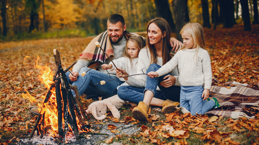 happy family in front of a bonfire during fall