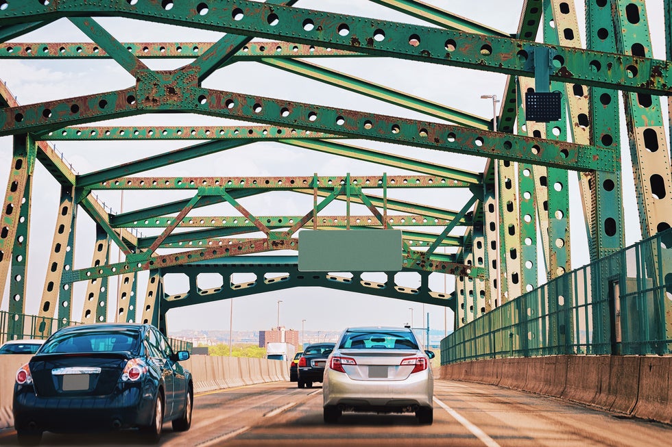Traffic moving across Newark NJ bridge near urban roadway corridor with vehicles and steel structure overhead