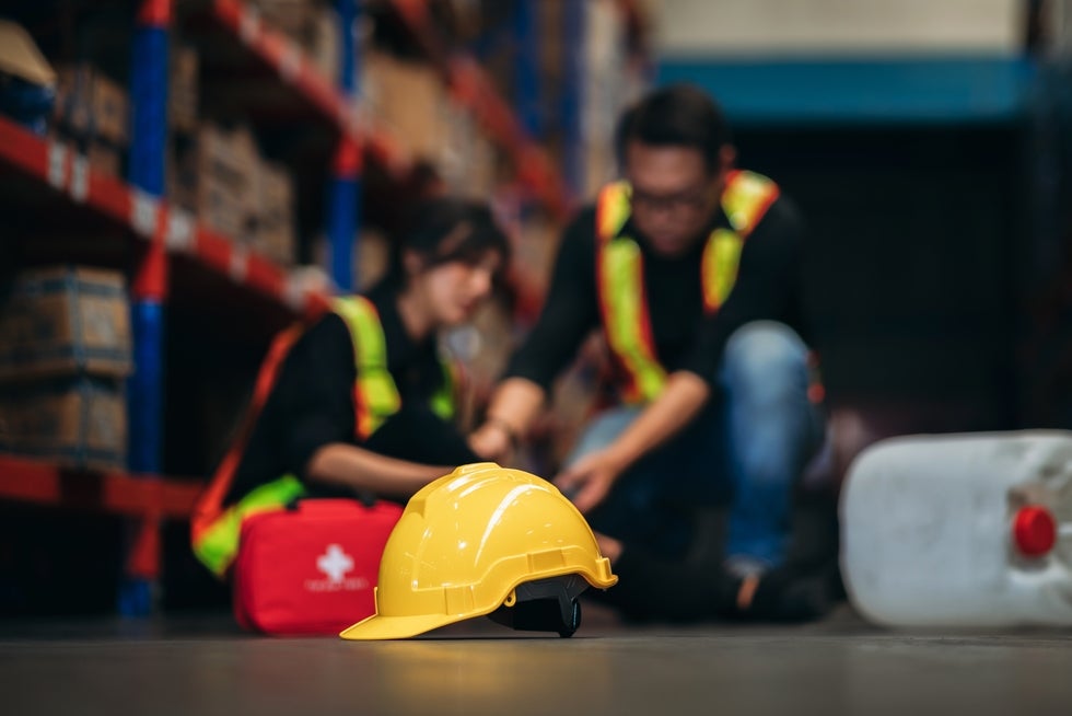 Warehouse worker receiving first aid after injury in Newark NJ, workers’ compensation claim scenario