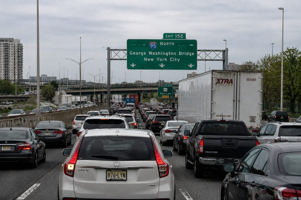 Heavy Memorial Day weekend traffic on a major New Jersey highway near the New York City skyline during sunset travel congestion